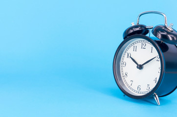 Alarm clock on blue background. Selective focus.