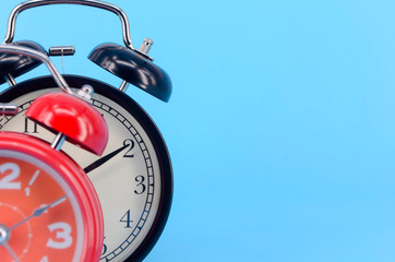 Alarm clock on blue background. Selective focus.