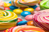 Fototapeta Tęcza - background of caramel and chocolate candies of different tastes and colors, side view