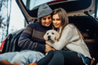 Cute young couple have a weekend time with their labrador retriver sitting in their car.