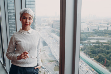 Portrait of stylish young woman in white sweater and glasses