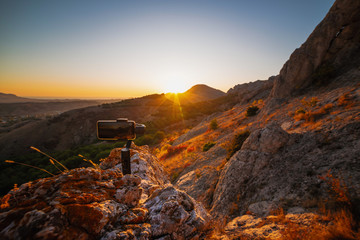 Poster - Monopod stabilizer for a mobile phone in the mountains at sunset