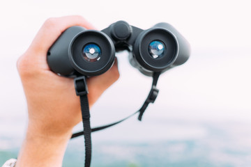 Wall Mural - Male hand with binoculars outdoor, pov.