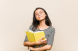 © Asier - Young asian woman student holding a book laughing and having fun.
