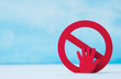 Red forbidden sign and hand  on blue background.