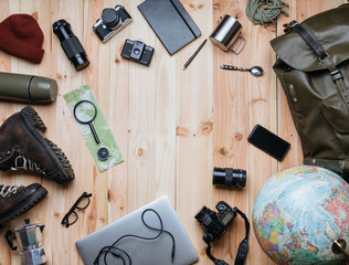 Creative arrangement of travel photography equipment on light raw wooden planks background