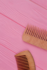 Wooden hair combs on pink background. Natural hair combs on color wooden surface. Flat lay, top view.