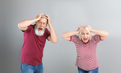 Canvas Print - Angry mature couple on grey background