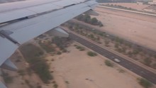 Aerial View Out Of An Etihad Airways Airbus A320-200s Right Window On Final Approach On Abu Dhabi International Airport Passing A Desert Highway While Sunset.