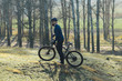 © Mountains Hunter - Cyclist in pants and fleece jacket on a modern carbon hardtail bike with an air suspension fork. The guy on the top of the hill rides a bike.