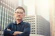 © pandaclub23 - Confident male business executive  with arms crossed standing in front of office building