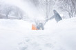 © soupstock - Man using a snowblower to clear his sidewalk and driveway, low visability