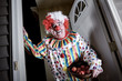 © soupstock - Awkward man dressed as a clown handing out apples for trick or treat on halloween
