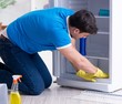 © Elnur - Man cleaning fridge in hygiene concept