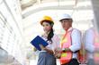 Portrait of multiethnic architect or engineer man and women or business industrial man engineer look away while standing at construction building