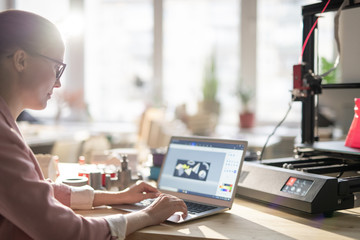 Canvas Print - Creative female designer sitting by desk in office and making electronic sketch