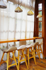 Wall Mural - Beautiful and bright interior with brown wooden bar stools and simple triangle lamp.       