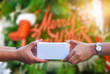 © Suriyo - Hand holding gift box Merry Christmas Text on Christmas tree concept background,Giving gift box and take