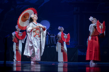 Wall Mural - Traditional Japanese performance. Actresses in traditional white and red kimono and fox masks dancing with umbrella and fans.