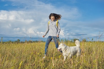 Active healthy lifestyle, teen girl running with white husky dog