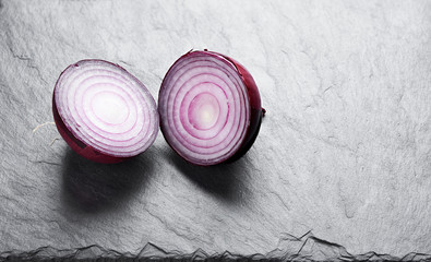 Sticker - red onion slices on a stone background