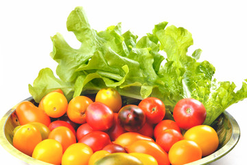 lettuce yellow and red tomatoes, cherry tomatoes on a vintage dish white background, isolate, top view