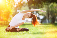 Yoga Outdoor. Happy Woman Doing Yoga Exercises, Meditate In The Park. Yoga Meditation In Nature. Concept Of Healthy Lifestyle And Relaxation. Pretty Woman Practicing Yoga On The Grass