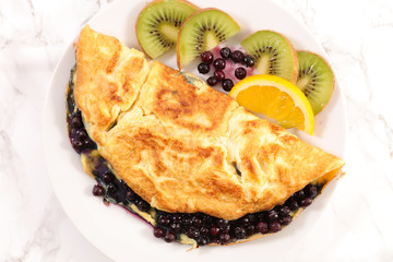 Wall Mural - fried egg omelet with blueberries and fruits