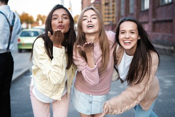 Outdoor shot of three young women having fun on city street