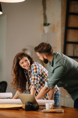 Wall Mural - Colleagues in office. Businesswoman and businessman discussing work in office. Two friends in working together.  