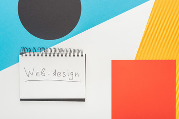 top view of notebook with web-design lettering on abstract geometric background