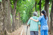 © Tom Wang - Smiling nurse helping senior woman to walk around the park