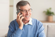 © Prostock-studio - Elderly Man Talking On Cellphone Sitting On Couch At Home