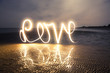 Light Painting Art: Writing love with light into darkness on the beach at a romantic twilight