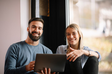 Poster - Young happy couple. Boyfriend and girlfriend using laptop together. 