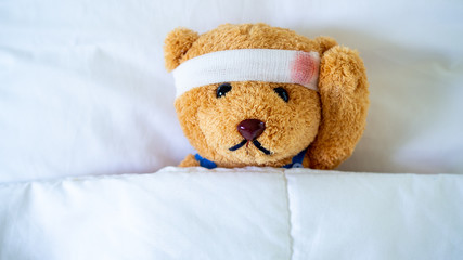 Wall Mural - The teddy bear was sick in bed after being injured in an accident. Getting life insurance and accident insurance concept