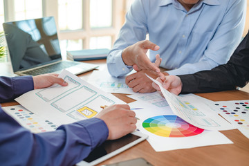 Teamwork graphic designers creative drawing website ux app development and application for mobile phone in the office.