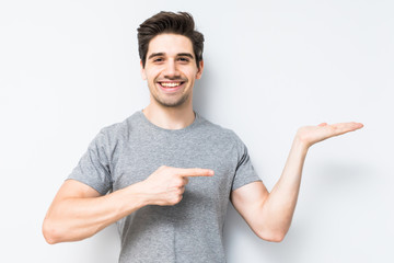 Young man showing something with his hand isolated on white background