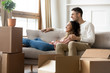 Happy couple dreaming relaxing in own home with boxes
