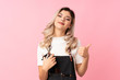 © luismolinero - Teenager girl over isolated pink background with hairdresser or barber dress with thumb up