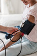 © Maskot - Cropped hand of nurse checking patient's blood pressure in medical room