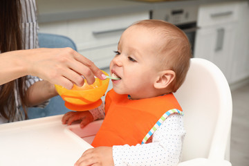 Canvas Print - Young mother feeding her little baby at home