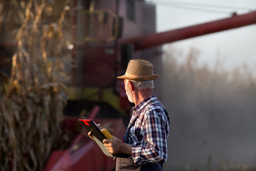 Canvas Print - Farmer in front of combine harvester