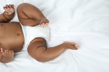 Wall Mural - American baby girl lying on white bed