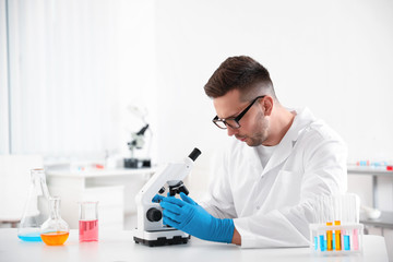 Poster - Scientist using modern microscope at table. Medical research