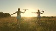 © zoteva87 - Happy childhood concept. Dreams of flying. Two girls play with toy plane at sunset. Children on background of sun with an airplane in hand. Silhouette of children playing on plane