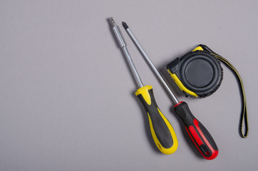 Poster - screwdrivers work tool, tape-measure on gray background, top view. Construction industry concept