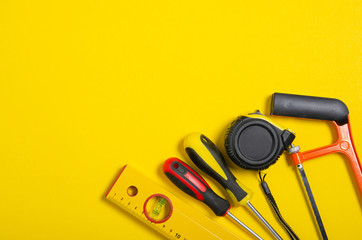 Wall Mural - Work hand tools on yellow background. Top view composition.