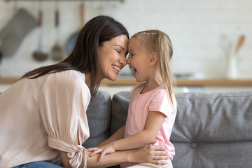 Wall Mural - Happy mother having fun with cute kid daughter on sofa