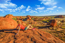 Tourist Woman On Nyanjiki Lookout At Sunset Admiring Panoramic Views And Vibrant Colors Of Gigantic Boulders Of Natural Rock Formations At Karlu Karlu Or Devils Marbles, Northern Territory, Australia.